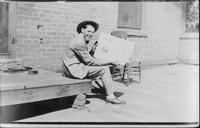 [Leonard Stroud sitting on a porch and showing rodeo program pages]