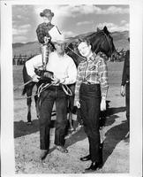 Bob Crosby, Carl Arnold and unidentified woman holding a trophy in front of a horse