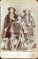 Hunters in cowboy hats & slickers with shotguns in studio