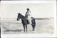 Glen Housley wearing wooly chaps & sitting atop horse