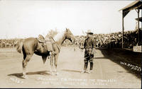President T. D. Taylor of the RoundUp and first prize 0 Saddle, No. 257