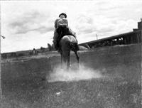 Cowboy on horseback riding away