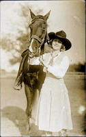 Bonnie McCarroll standing beside saddled horse