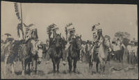 [5 Native Americans on horseback in full dress, all are covering their faces with cloth or feathers]