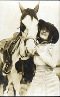 Bonnie McCarroll standing beside saddled horse