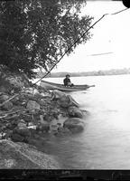 [Man in rowboat at edge of river, Shawnee]