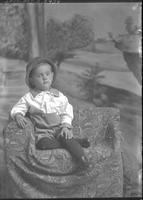[Single portrait of young Boy in chair wearing a two piece suit]