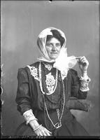 Woman wearing Scarf as worn in open buggy or early road car.