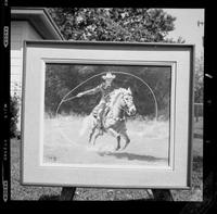 [Framed picture of Junior Eskew spinning a loop while riding a horse]