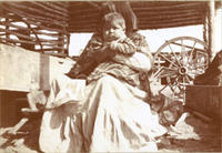 [Sitting Indian woman with child on lap]
