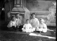 [Single portrait of a group including young Boys, young Girls & an Infant]