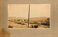 [Longshot of unidentified town (perhaps McCoy) showing buildings and hills]