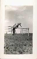 [Unidentified man sending a horse jumping over a hurdle]