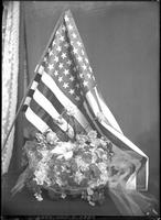 [Bowl of flowers in front of United States Flag]