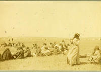 [Indian women and children sitting on ground in circle at social event]