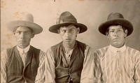 [Three Mexican cowboys wearing hats]