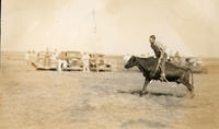 [Unidentified man riding a steer]