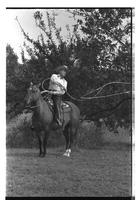 [Junior Eskew, sitting atop horse, spins loop for November 1969 Western Outfitter article]