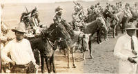 [Costumed Indian men atop horses with an Indian Cowboy in wooly chaps standing in foreground]