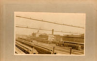 [Unidentified railroad hub with numerous cars near buildings]