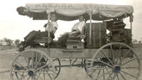 [Two unidentified women with luggage sitting in wagon called the Alzada Stage]