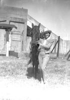 [Possibly Mamie Stroud standing by horse in front of building]