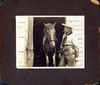 [Cigarette smoking cowboy with horse, holster, and leather chaps]