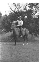 [Junior Eskew, sitting atop horse, spins loop for November 1969 Western Outfitter article]