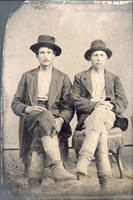[Two people posed for a portrait wearing hats and boots]