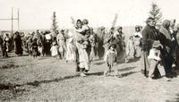 [Long line of Indian women and children walking]