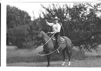 [Junior Eskew, sitting atop horse, spins loop for November 1969 Western Outfitter article]