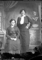 [Single portrait of two adult Females, one sitting & one standing]