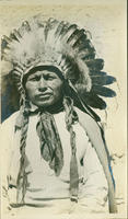 [Southern Ute man with full headdress and braids]