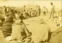 [Indian women sitting on ground watching the cattle butchering in corral]