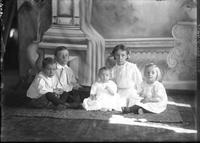 [Single portrait of a group including young Boys, young Girls & an Infant]