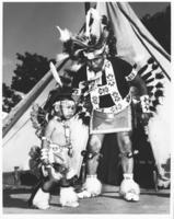 [Indian man and boy standing in front of tipi]
