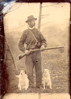 [Hunter with dogs holding rifle]