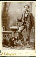 [Well-dressed man with Winchester rifle and hunting dog]