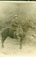 [Cowboy on horseback with wooly-saddlebags and spurs]