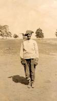 [Unidentified man in cowboy hat standing nearly at attention]