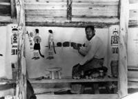 Jack Hokeah seated and working on mural