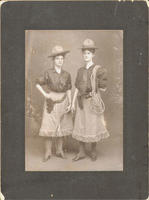 [Two young women dressed as cowgirls and packing pistols]