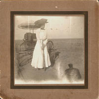 [Woman with rifle near horseless carriage]