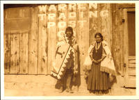 [Two Navajo with rug and blanket near Warren Trading Post]