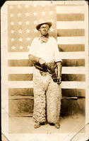 [Black cowboy posed in front of American flag]