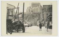 [Street scene with horse-drawn cart and streetcar]