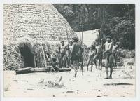 [Group of native Venezuelan people with spears in front of huts]