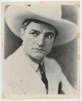 [Tom Mix in white suit, long tie, and hat]