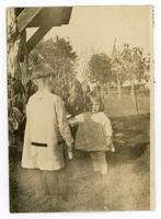 [2 children standing near garden]