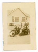 [man and teenage boy sitting on a motorcycle in front of house]
